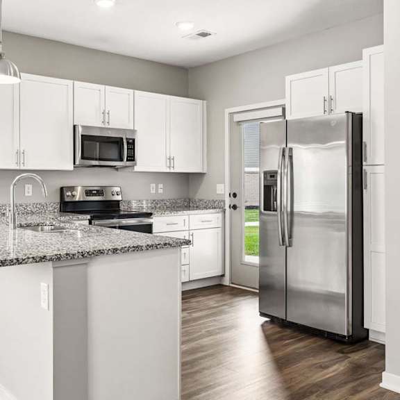 Thumbnail 17 of 21 A kitchen with a granite countertop and stainless steel appliances.