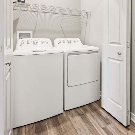 Thumbnail 20 of 21 A white laundry room with a washer and dryer.
