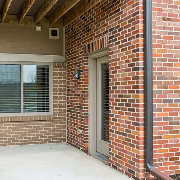 Thumbnail 21 of 21 A red brick house with a window and a door.