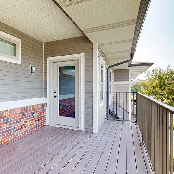 Thumbnail 22 of 26 A spacious balcony with a windowed door into the living room.