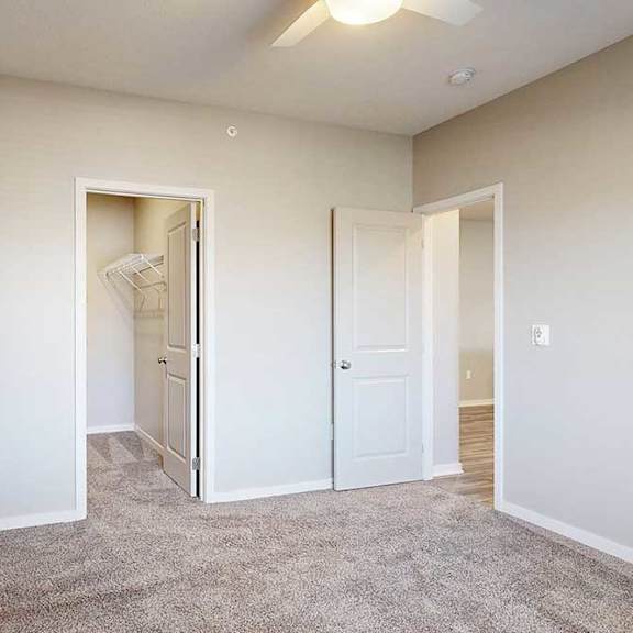 Thumbnail 25 of 26 A room with a carpeted floor and two doors, one of which is open.