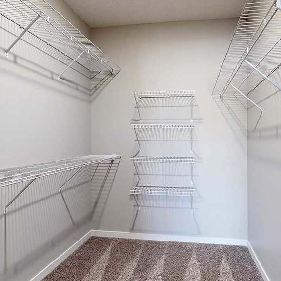 Thumbnail 3 of 26 An oversized walk-in closet with several built-in wire shelves.