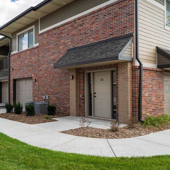 villa building exterior with sidewalk and private entrances