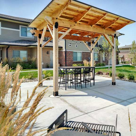 outdoor patio with table and couch, covered by wooden pergola