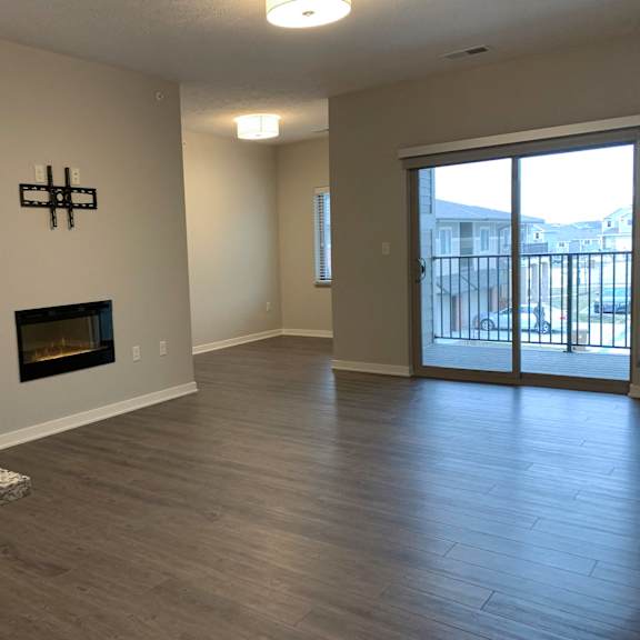 Thumbnail 8 of 21 A room with a fireplace and sliding glass doors.