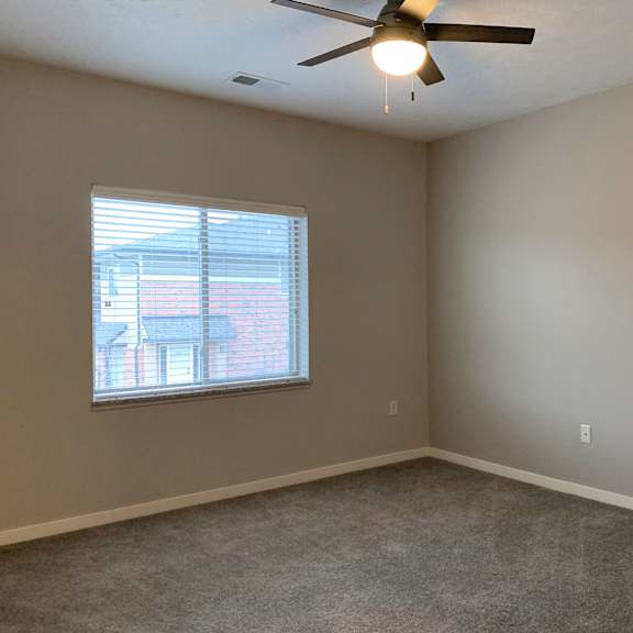 Thumbnail 11 of 21 A room with a ceiling fan and a window.