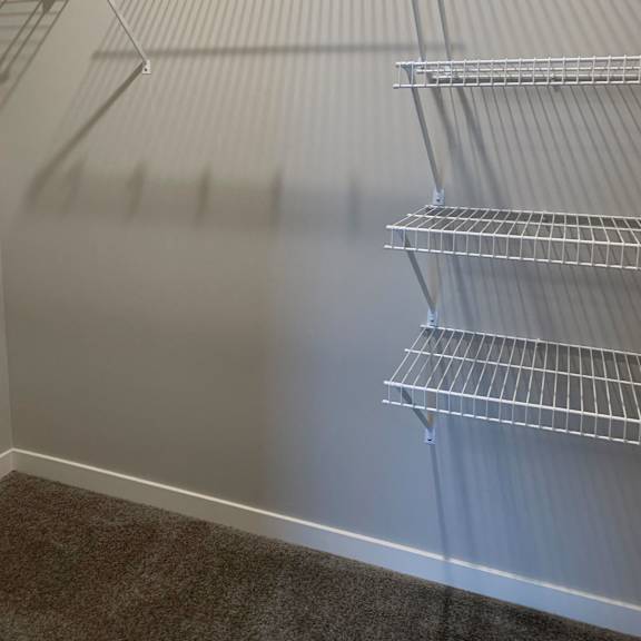 Thumbnail 12 of 21 Empty wire shelving in a room.