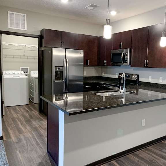 Thumbnail 19 of 21 A kitchen with dark wood cabinets and stainless steel appliances.