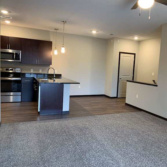 Thumbnail 20 of 21 A spacious kitchen with dark wood cabinets and stainless steel appliances.