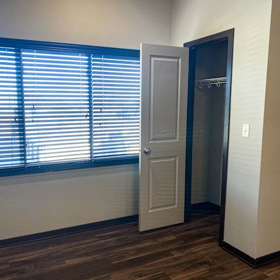 Thumbnail 18 of 23 A room with a door and a window with blinds.