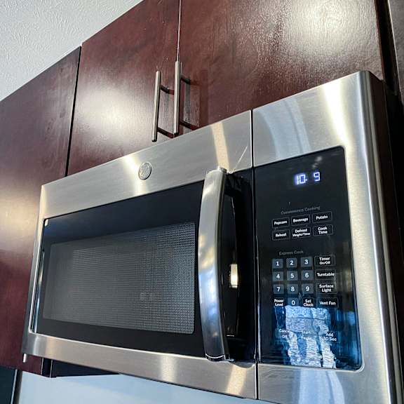 Thumbnail 21 of 23 A stainless steel microwave with digital display and control panel.