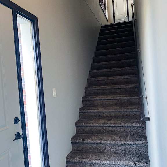 Thumbnail 23 of 23 A staircase with a carpeted runner and a black handrail.