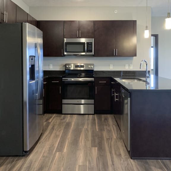 Thumbnail 5 of 26 Kitchen with dark brown cabinets and matching stainless steel appliances at the villas at mahoney park