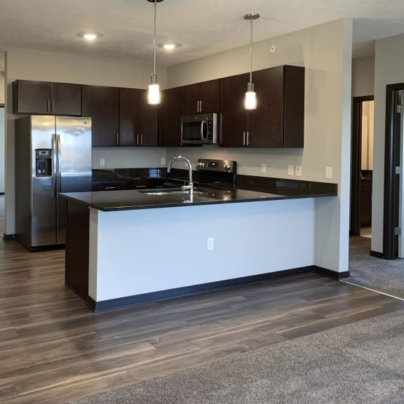 Thumbnail 8 of 26 Kitchen with dark brown cabinets and matching stainless steel appliances at the villas at mahoney park