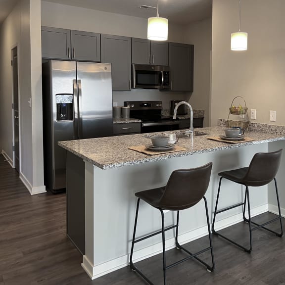 Thumbnail 4 of 8 Kitchen with slate gray cabinets and matching stainless steel appliances at The Villas at Mahoney Park