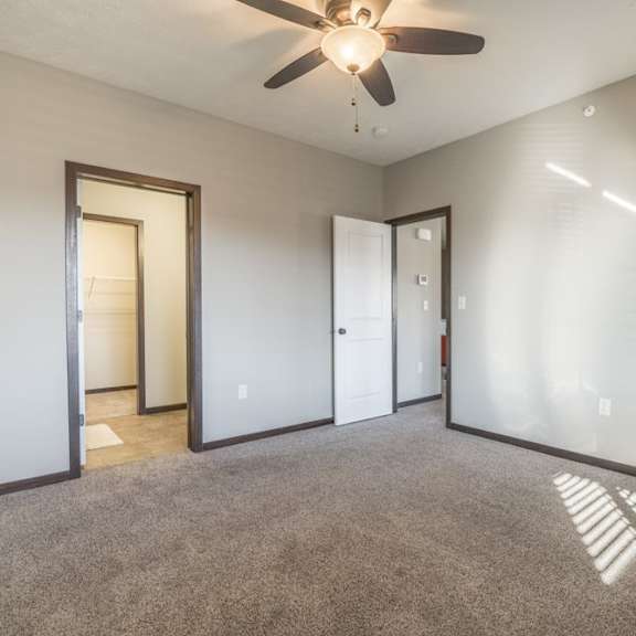 Thumbnail 9 of 11 A room with a ceiling fan and carpeted floor.