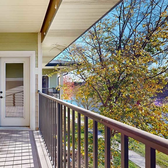 Thumbnail 10 of 22 a balcony overlooking a pond with a window to the bedroom and a door to the living room
