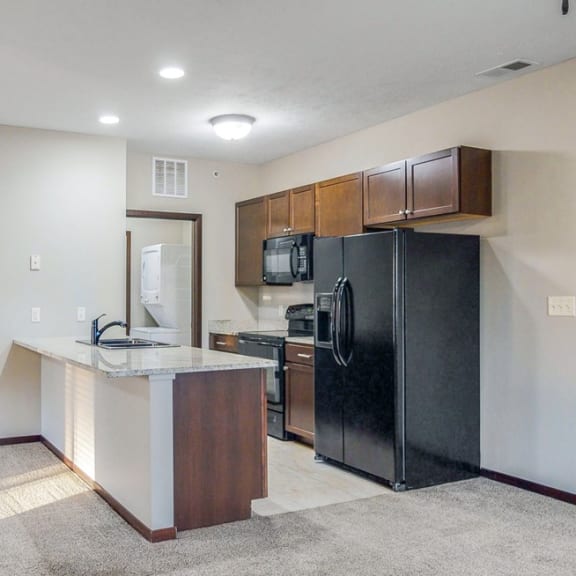 Thumbnail 2 of 19 The kitchen in the Ash features a peninsula counter with room for seatingat The Villas at Wilderness Ridge luxury apartments in southwest Lincoln NE 68512