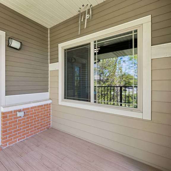 Thumbnail 27 of 30 A white door is open to a balcony with a brick pillar.