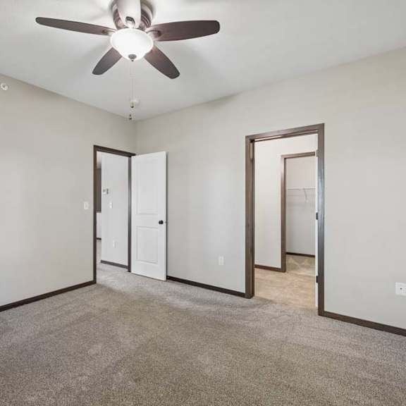 Thumbnail 26 of 30 A room with a ceiling fan and carpeted floor.