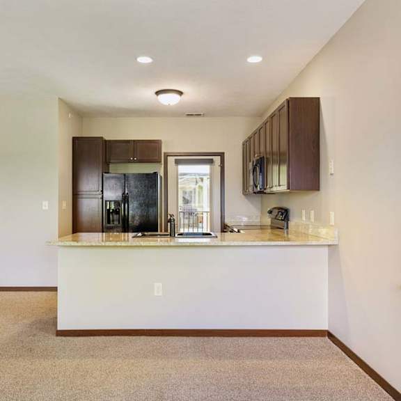 Thumbnail 29 of 30 A kitchen with a white countertop and brown cabinets.