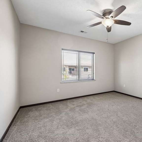 Thumbnail 32 of 40 A room with a ceiling fan and a window with blinds.