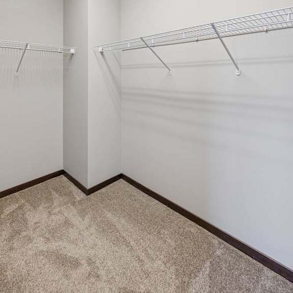 Thumbnail 37 of 40 A white closet with two shelves and a carpeted floor.
