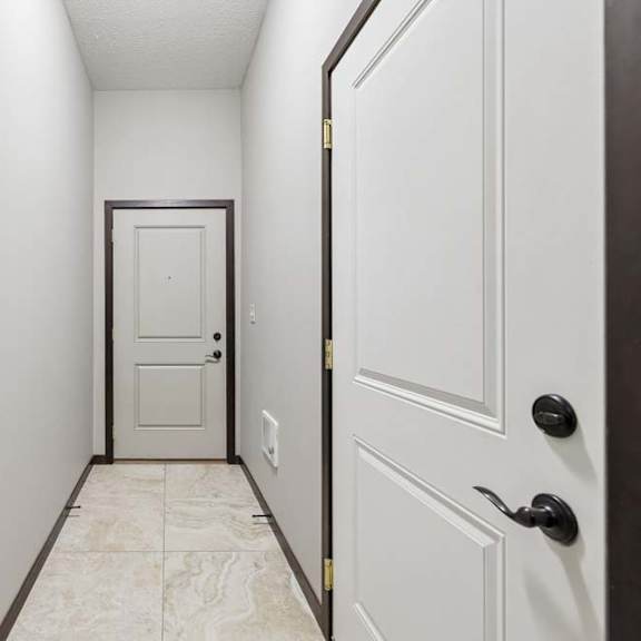 Thumbnail 40 of 40 A hallway with a white door and a black door.