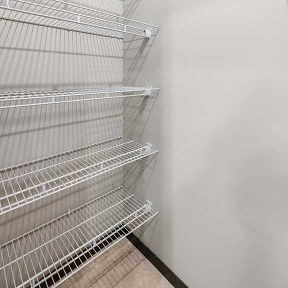 Thumbnail 9 of 19 Empty shelves in a white room.