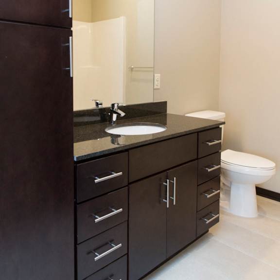Thumbnail 16 of 17 A bathroom with a sink, mirror, and toilet.