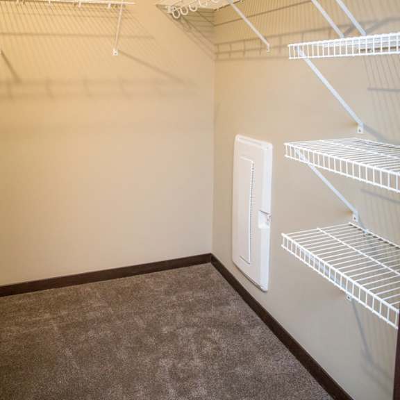 Thumbnail 17 of 17 Empty white shelves in a room with a door.