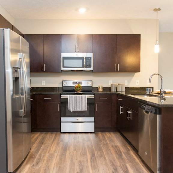 Thumbnail 13 of 17 A modern kitchen with dark wood cabinets and stainless steel appliances.