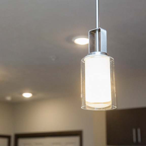 Thumbnail 14 of 17 A modern pendant light is hanging from the ceiling in a room.