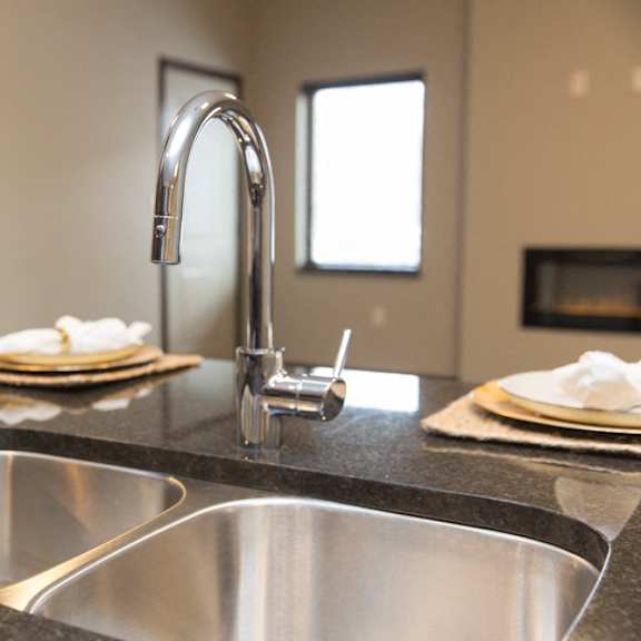 Thumbnail 15 of 17 A modern kitchen with a stainless steel sink and faucet.