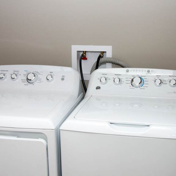 Thumbnail 13 of 13 Two white front loading washing machines in a laundry room.