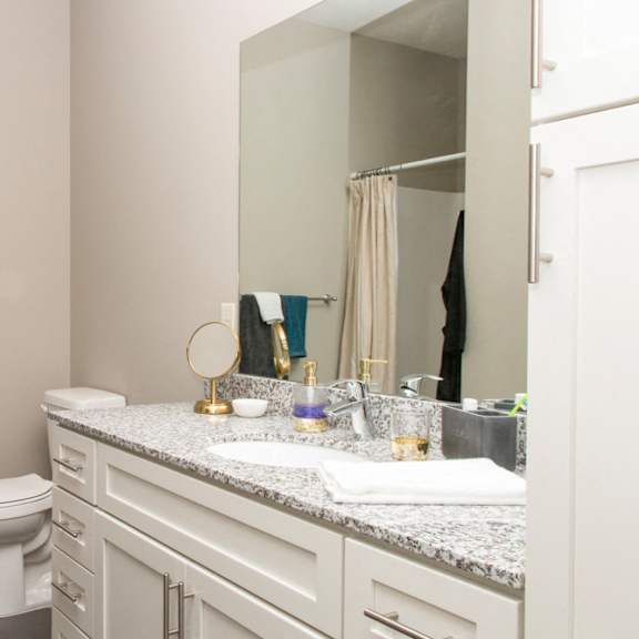 Thumbnail 11 of 13 A bathroom with a toilet, sink, and mirror.