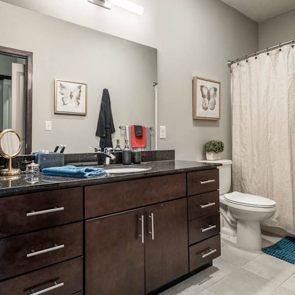 Thumbnail 16 of 16 Bathroom with dark cabinets and light tile floors at The Villas at Mahoney Park