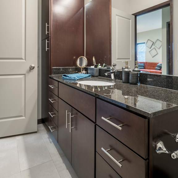 a bathroom with a sink, mirror, and cabinets.