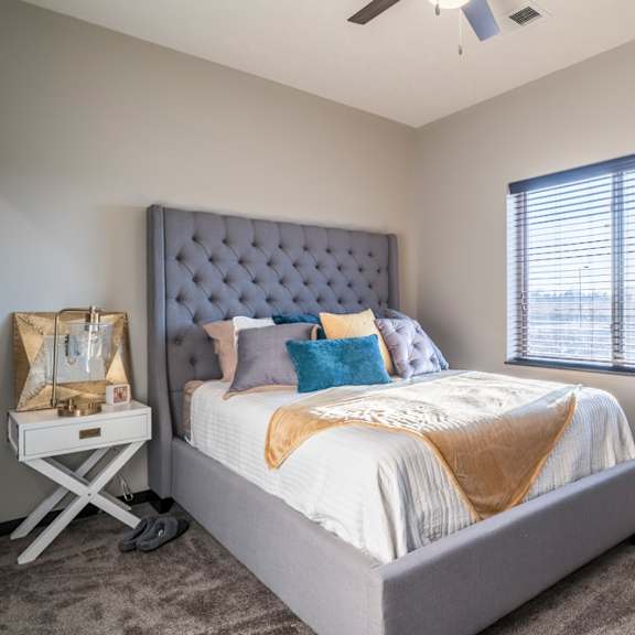 a bedroom with a large bed and a window with blinds.