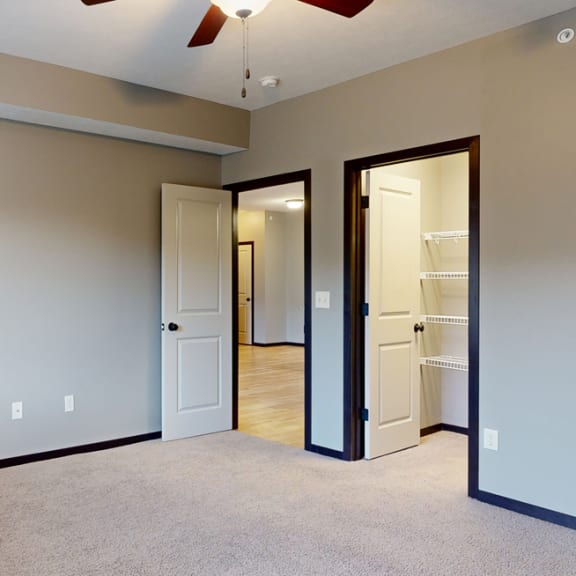 Thumbnail 10 of 17 a bedroom with a ceiling fan and a door to walk in closet