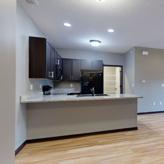 Thumbnail 3 of 17 an open living room and kitchen area with a ceiling fan