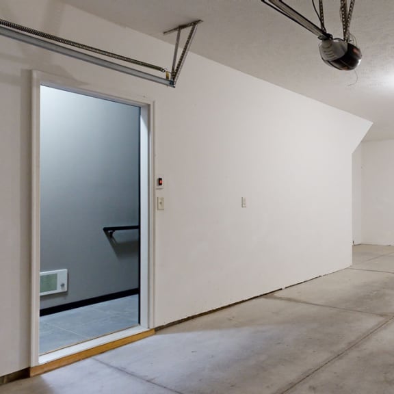 Thumbnail 17 of 17 spacious tandem garage with a white walls and concrete floor