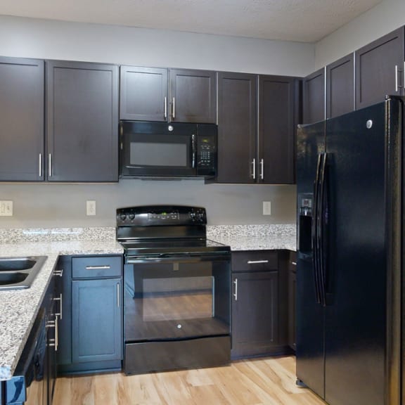 Thumbnail 5 of 17 a kitchen with dark cabinets and granite countertops