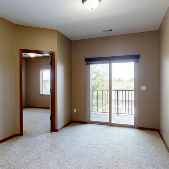 Thumbnail 11 of 20 an living room with a  sliding glass door to the balcony and an open door to a bedroom