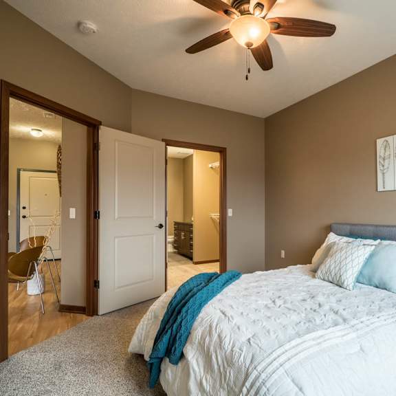 Thumbnail 9 of 15 A bedroom with a large bed and a ceiling fan.