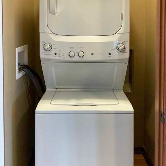 Thumbnail 18 of 19 A stacked washer and dryer in a laundry closet.