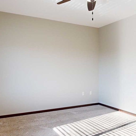 Thumbnail 17 of 22 a carpeted bedroom with a ceiling fan, a large window, and an attached walk-in closet