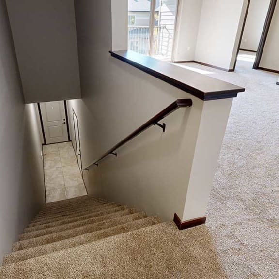 Thumbnail 3 of 22 a stair case leading down to an entryway, front door, and door to the attached garage
