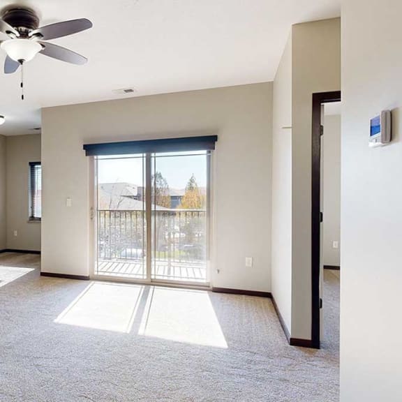 Thumbnail 11 of 22 a living room with a sliding glass door to a balcony, a ceiling fan, and an attached den space