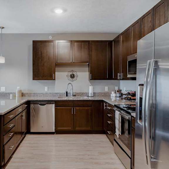 Thumbnail 4 of 17 A modern kitchen with dark wood cabinets and stainless steel appliances